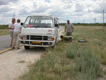 Cuan shows his expertise as a car mechanic with a puncture on the road from Grootfontein to Rundu
